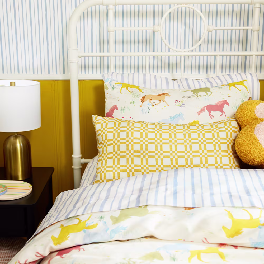 A kids bedroom with striped, check, and whimsical horse bedding.