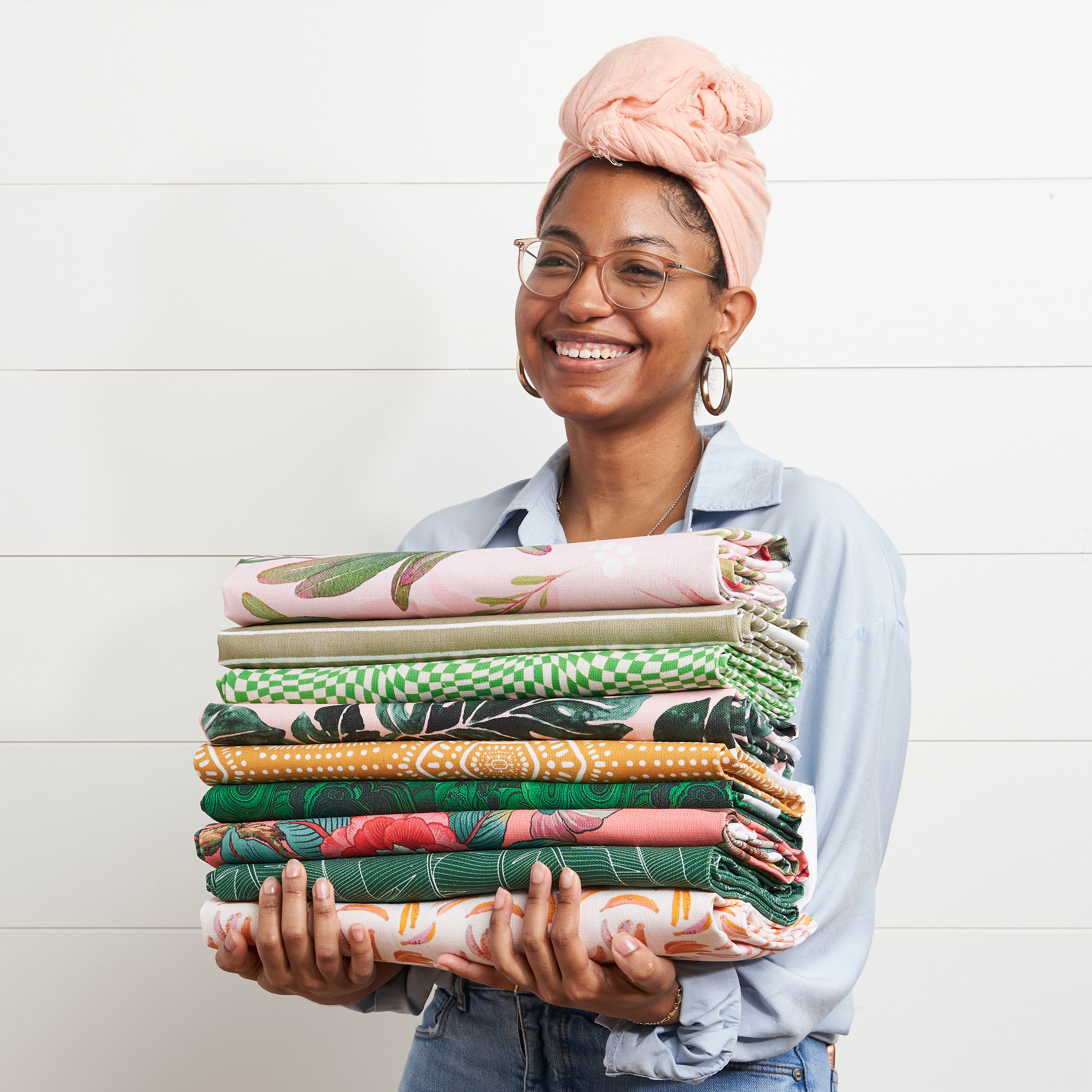 Person holding a stack of folded fabric