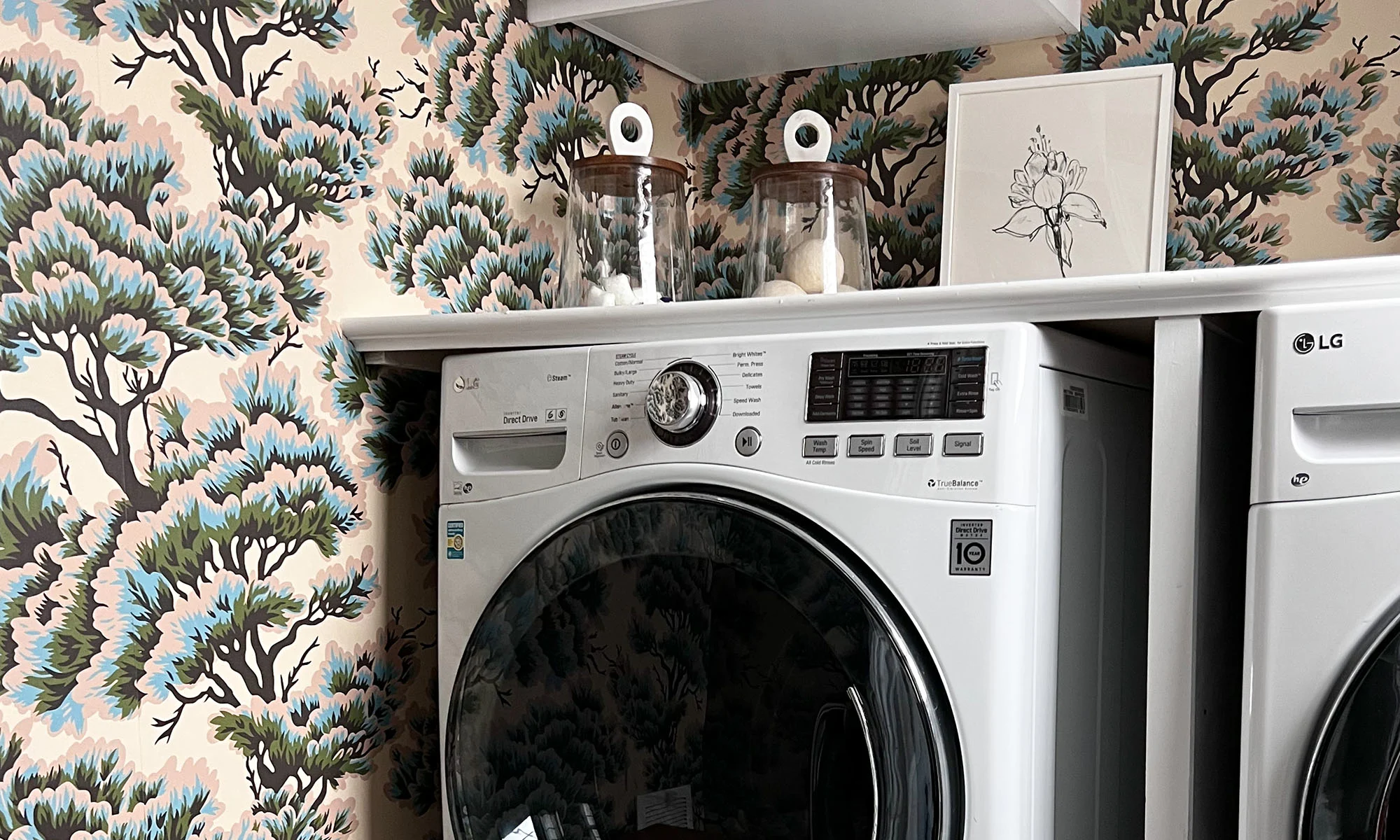 Laundry room with a tree wallpaper.