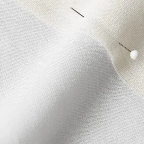 A close-up photo of white fabric with a pin running through it
