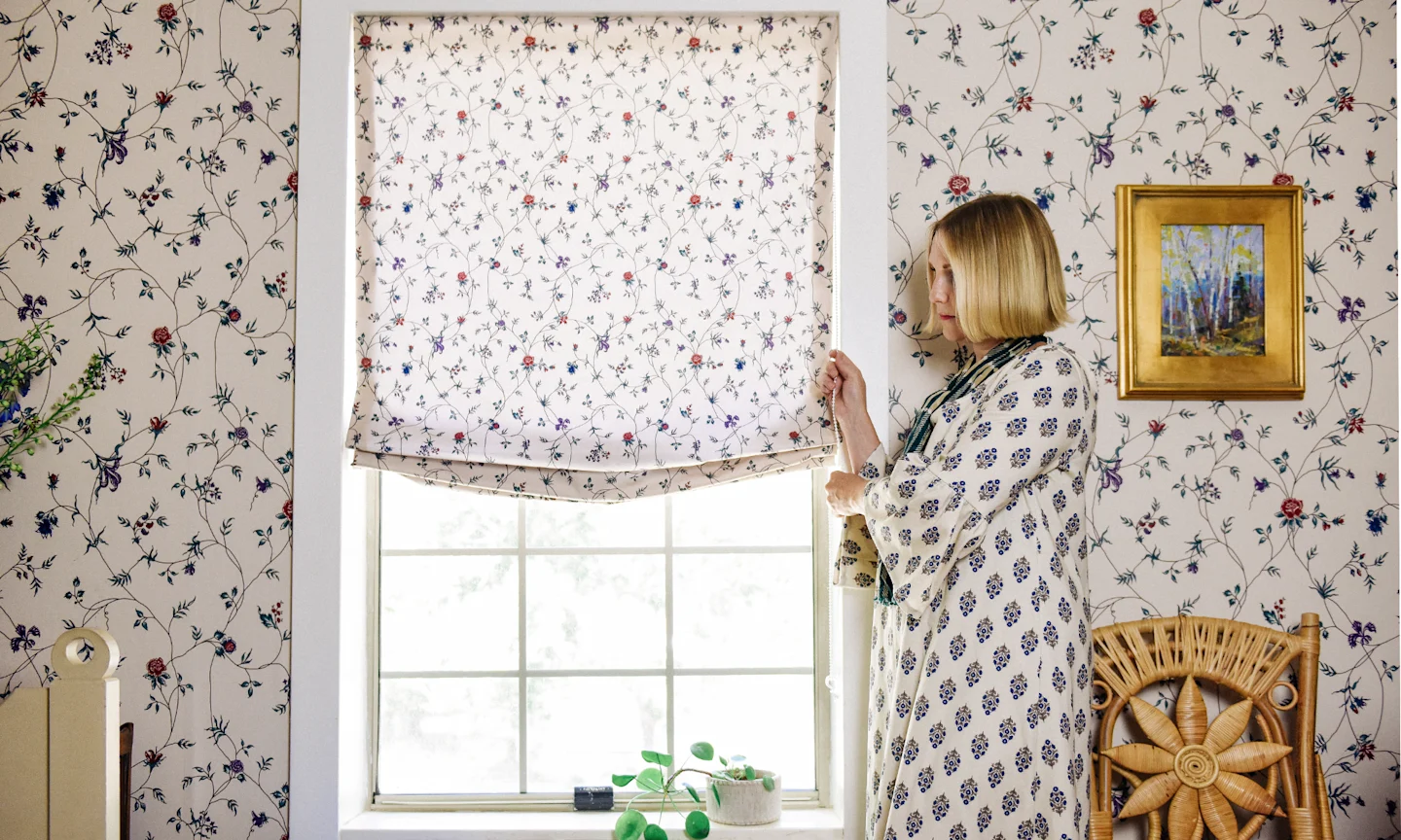 Brittany Jepsen of the House that Lars Built rolling up roman shades made out of Spoonflower fabric.