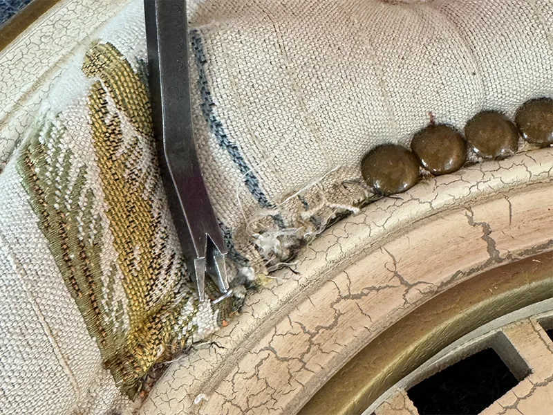 A close up of the staple remover near where tacks and staples were.