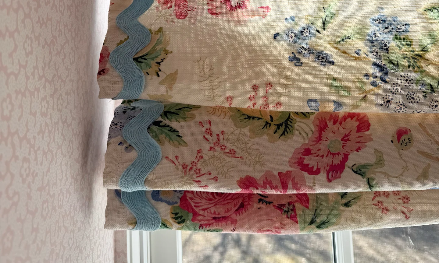 Close of of roman shades made with belgian linen fabric that has a floral chintz pattern.