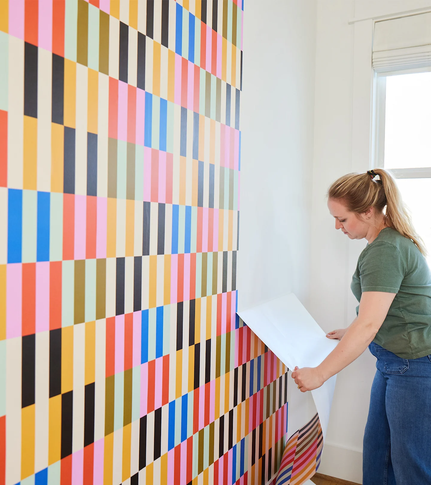 Person removing peel and stick wallpaper.