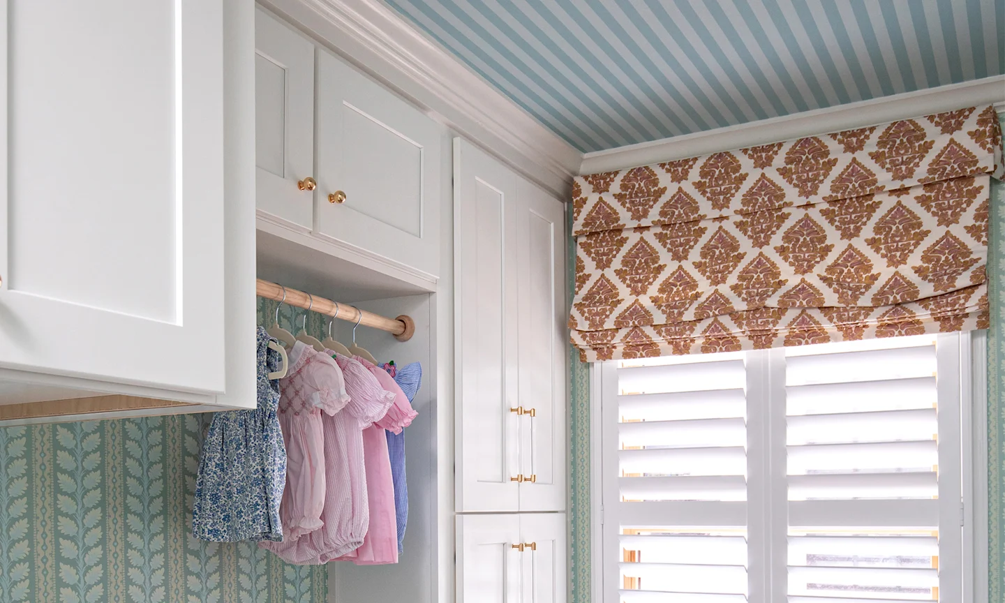 laundry room with striped wallpaper on the walls and ceiling and custom roman shades.