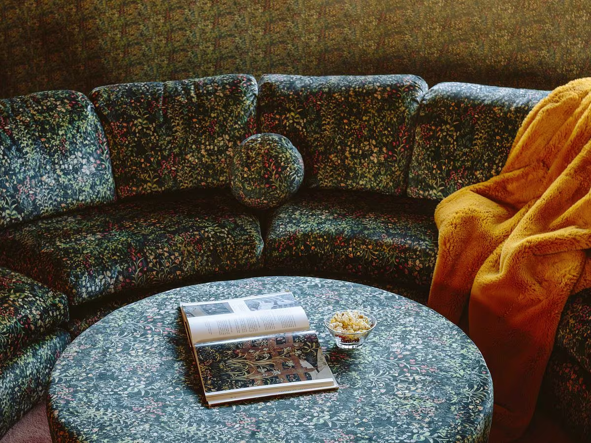 A Celosia Velvet couch in dark green floral by Emily Henderson