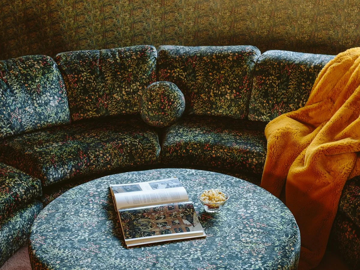 A Celosia Velvet couch in dark green floral by Emily Henderson