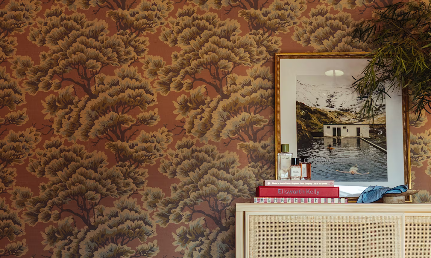 Bedroom with mauve tree wallpaper.