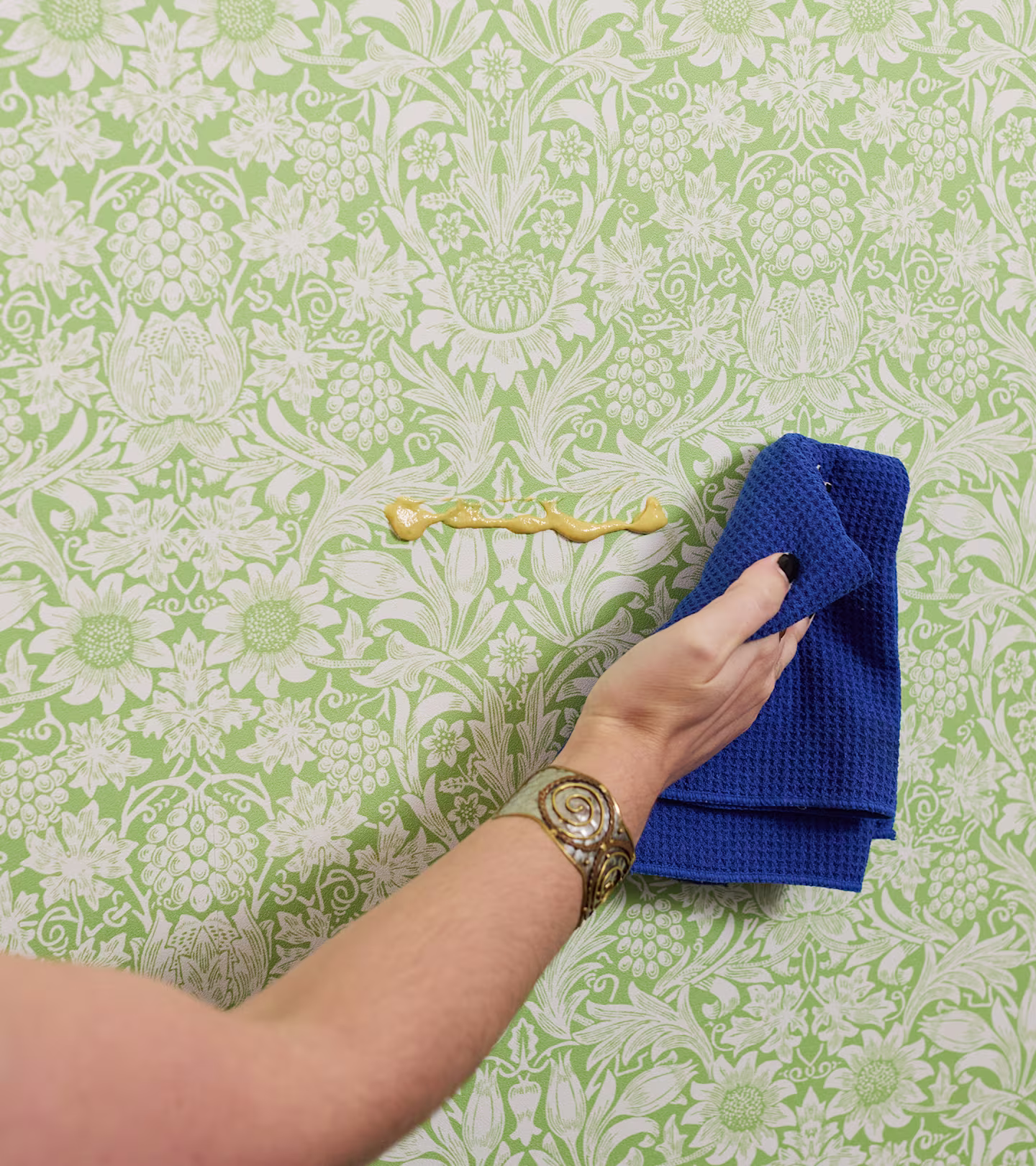 Person wiping mustard off off wallpaper.