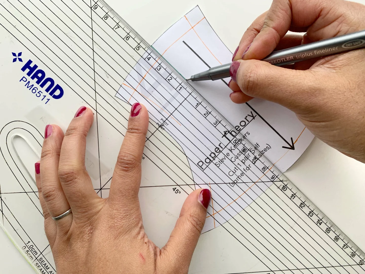 Drafting the new underwear pattern by marking stitch lines on the paper