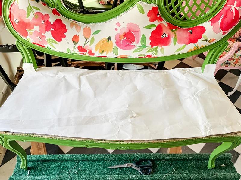 Paper placed on the settee chair's seat indicating a template for the foam covering.