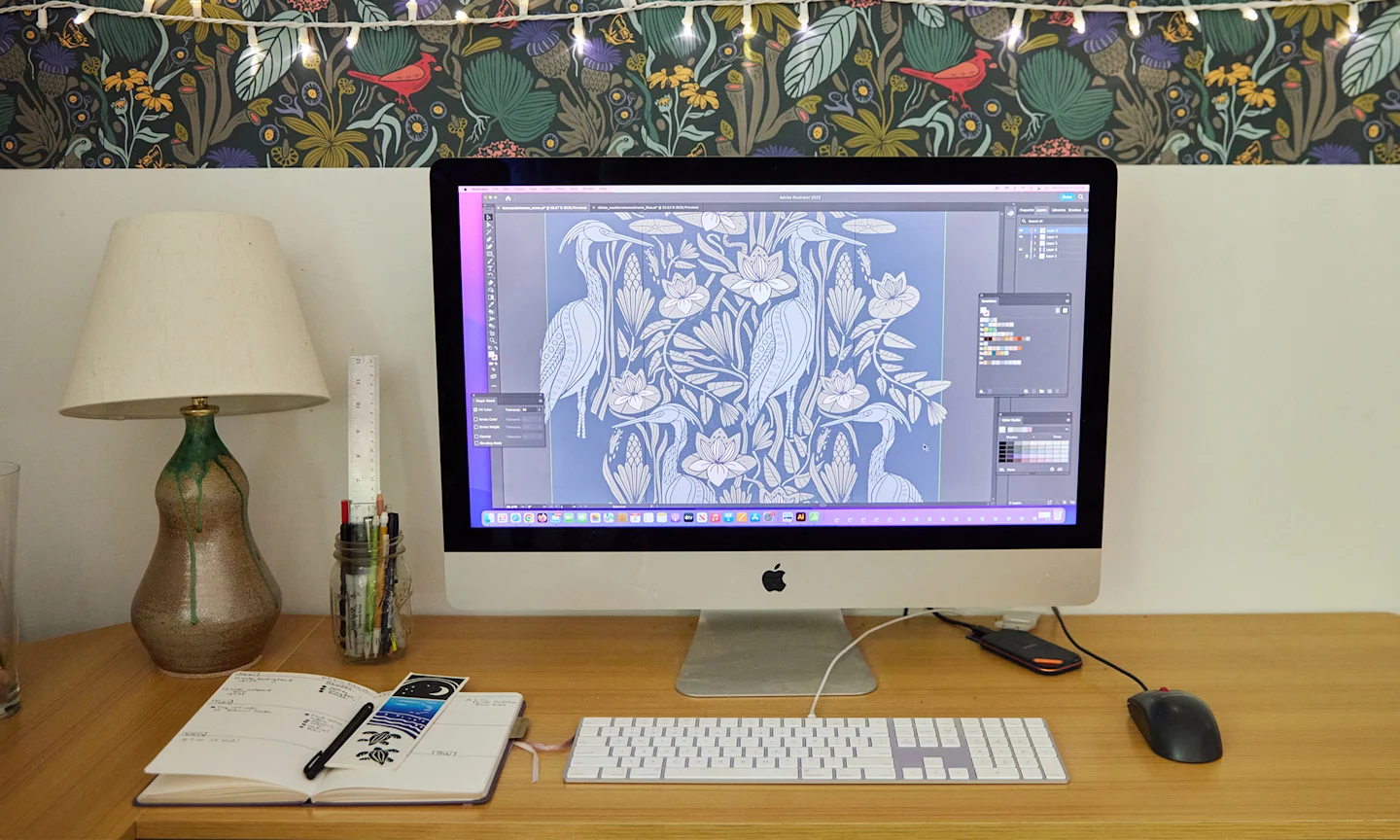 Mac computer on a desk with a design open in Photoshop.