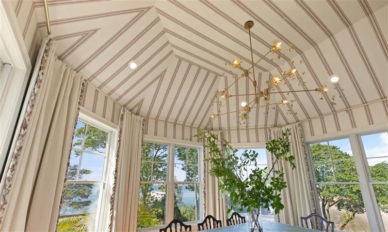 Dining room covered with striped wallpaper on walls and ceiling.