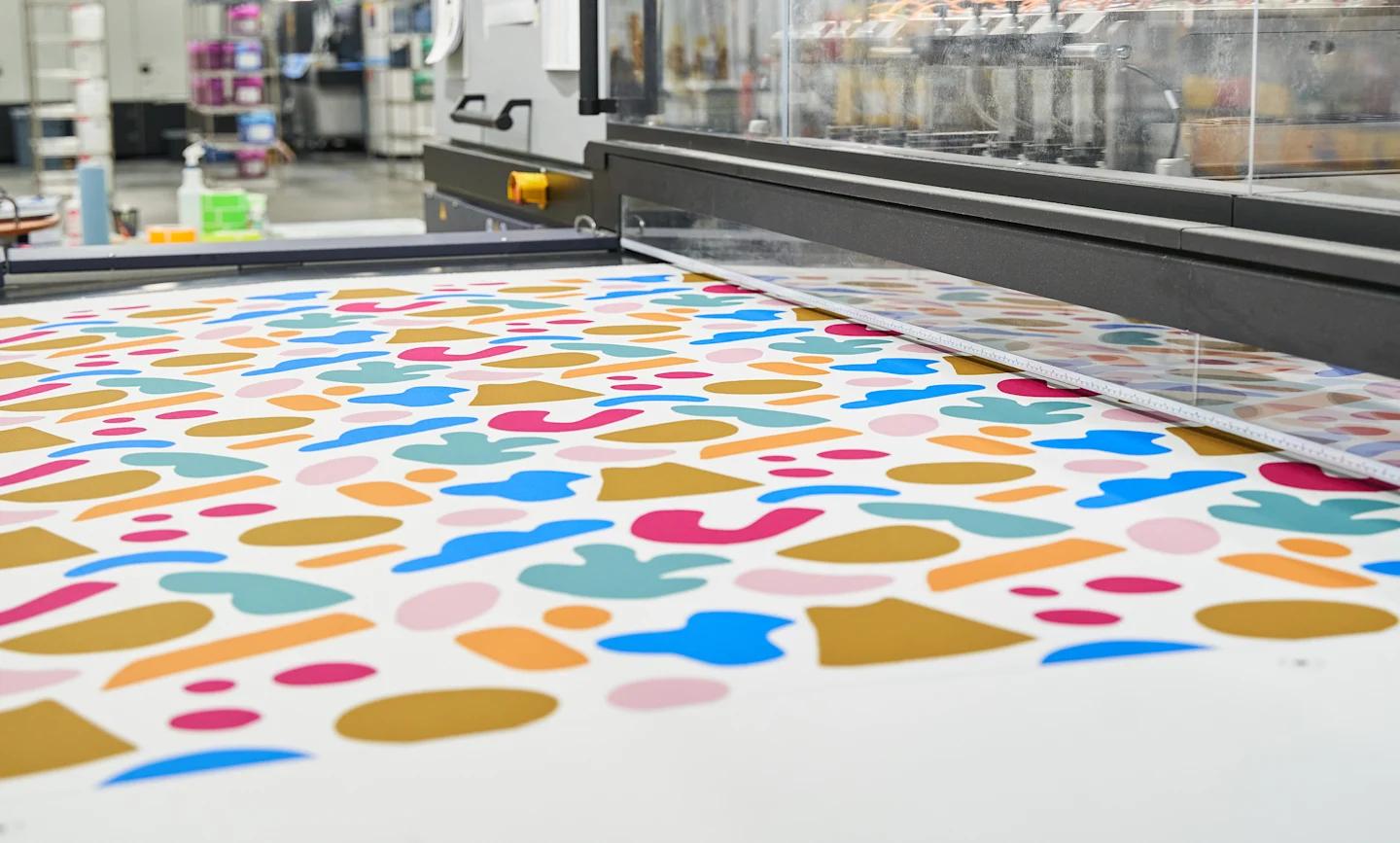 Colorful fabric being printed in a Spoonflower manufacturing facility.