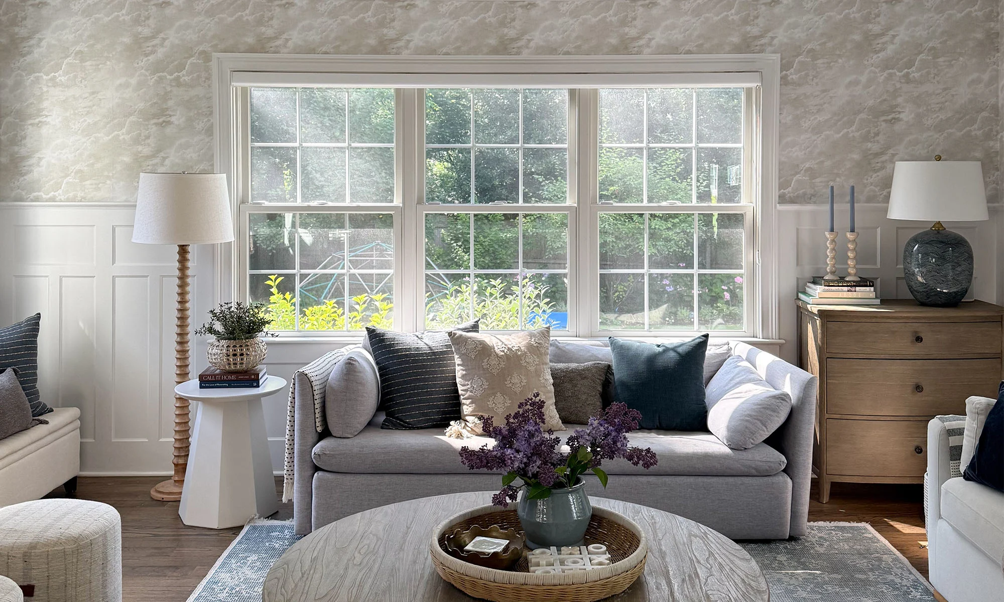Living area with serene clouds design wallpaper and a comfy couch.