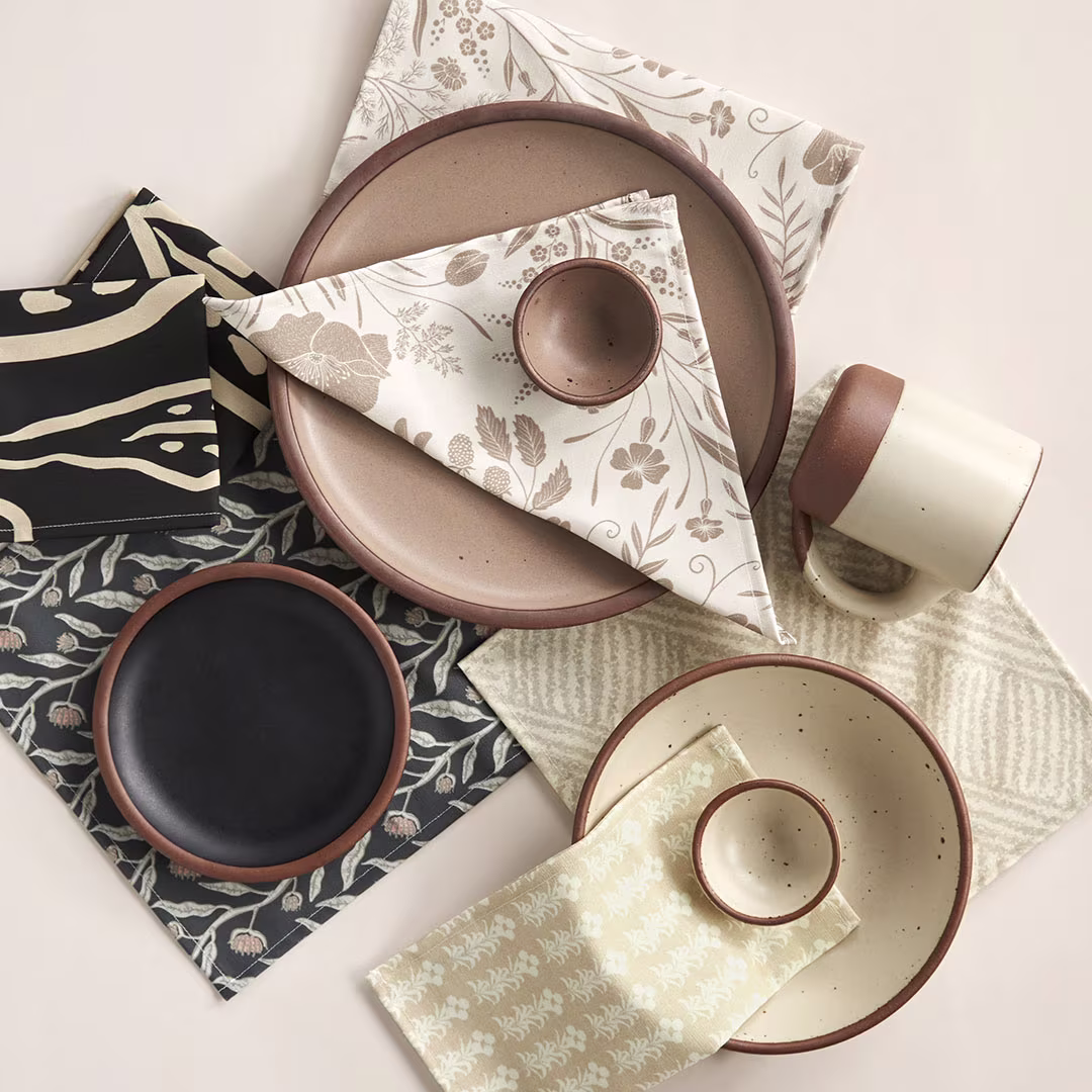 Plates with a variety of cloth napkins on or under the plates.