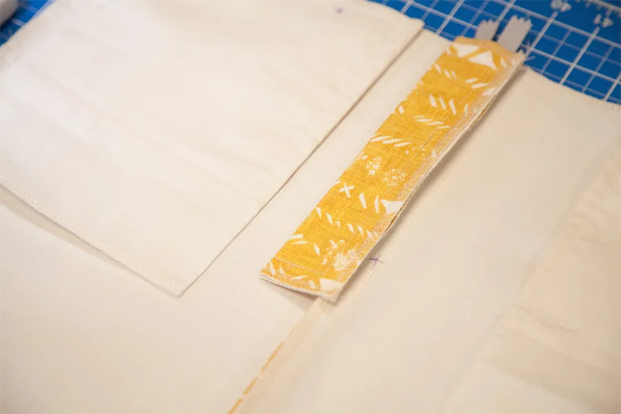 A close up of the fly extension. The top of the zipper is visible above the fly extension.
