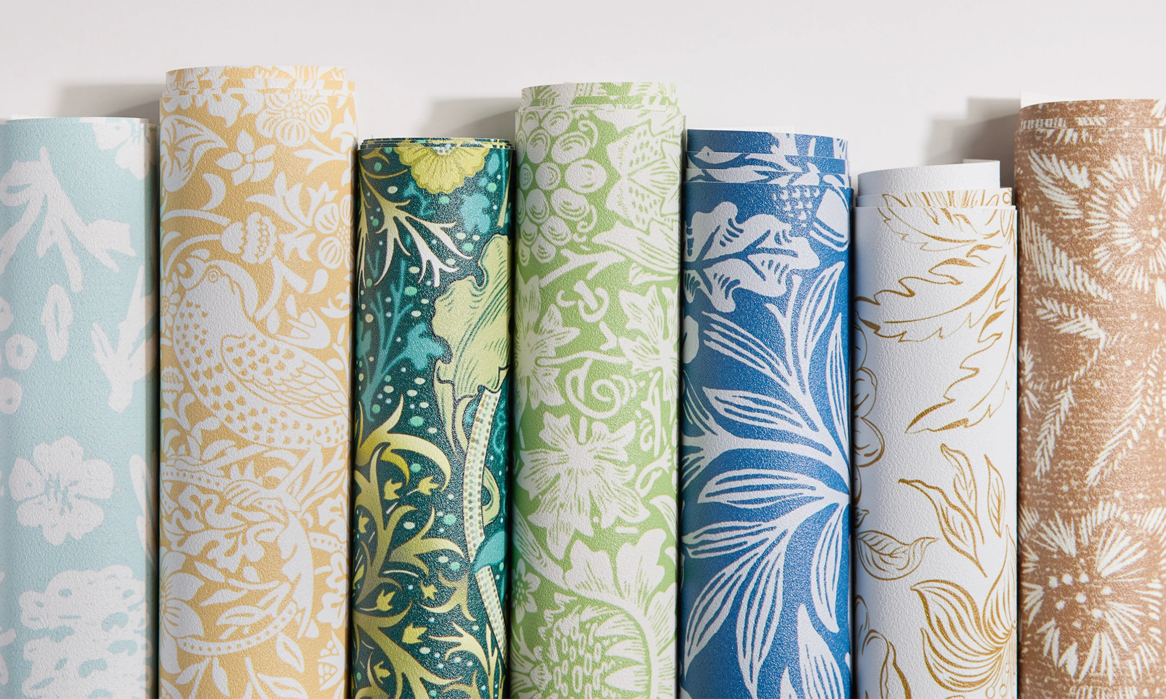 Ornate floral designs on rolls of vinyl wallpaper.