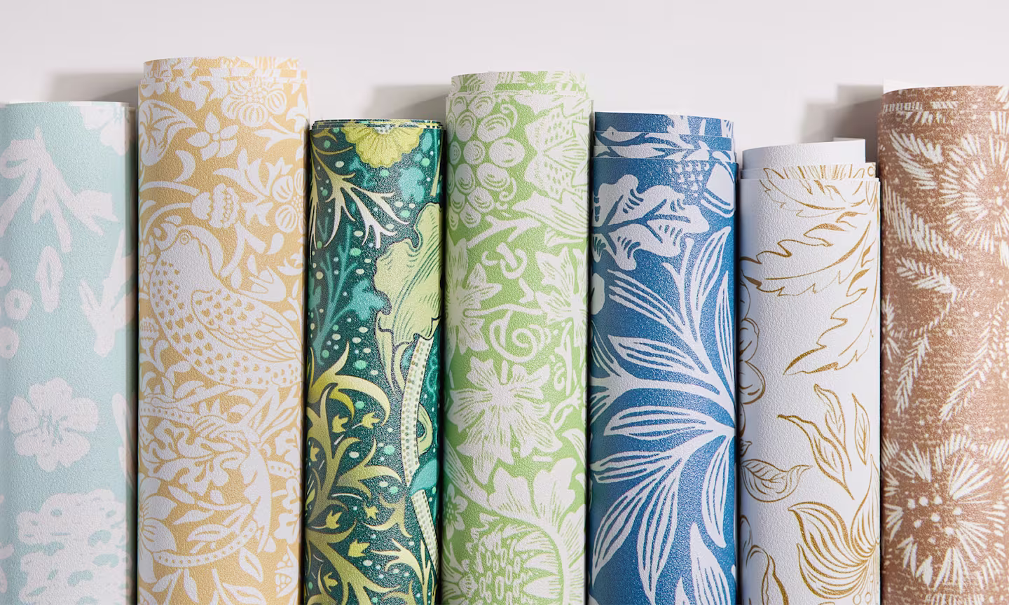 Ornate floral designs on rolls of vinyl wallpaper.