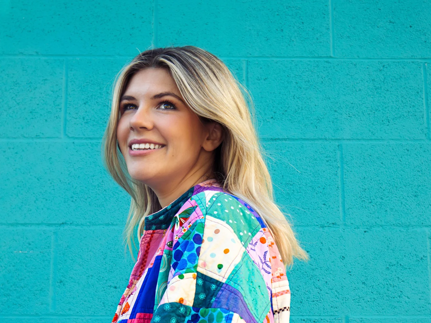 A headshot of Jenna Hall in a handmade quilted coat