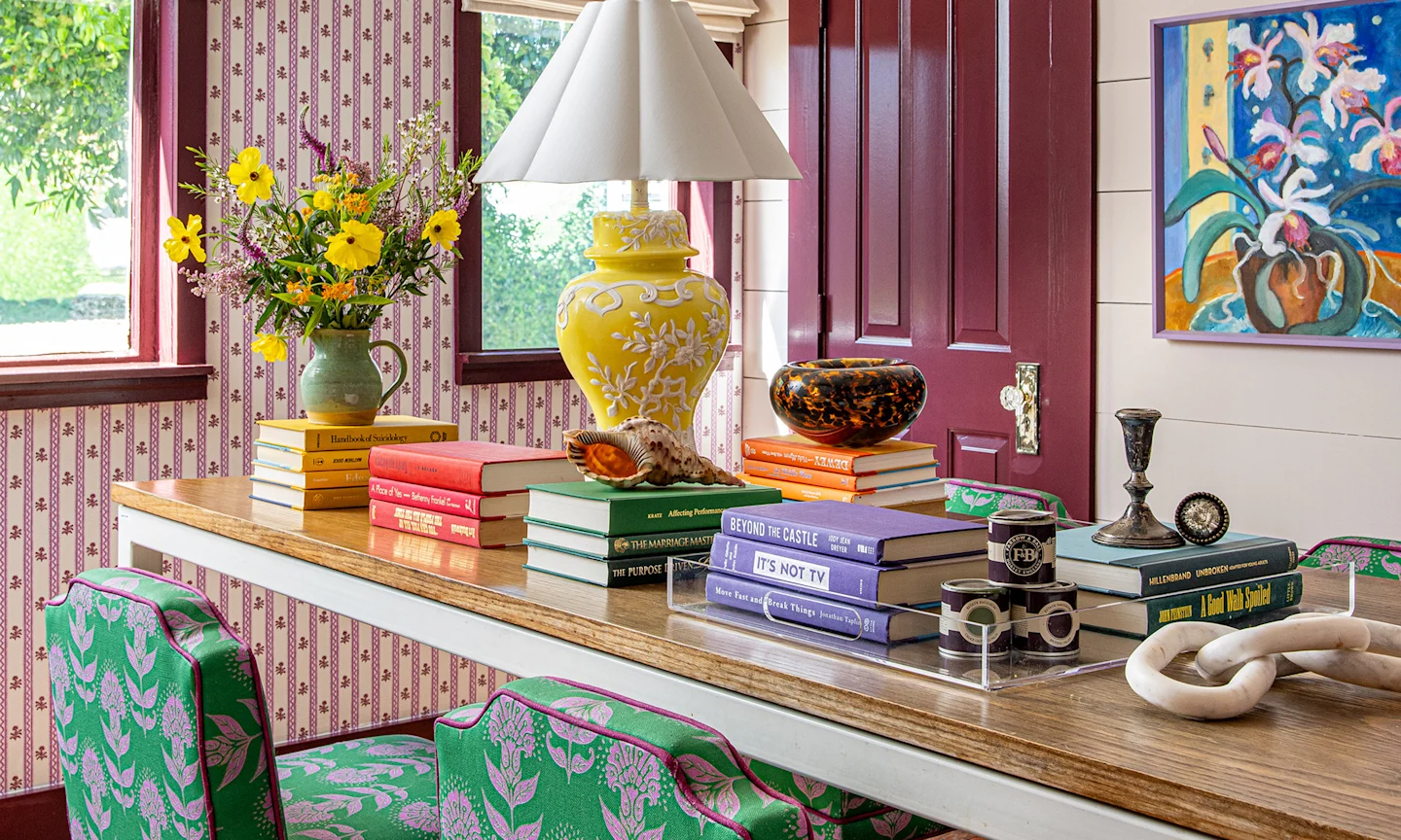 Home office with Block printed purple wallpaper and coordinating green upholstered chai