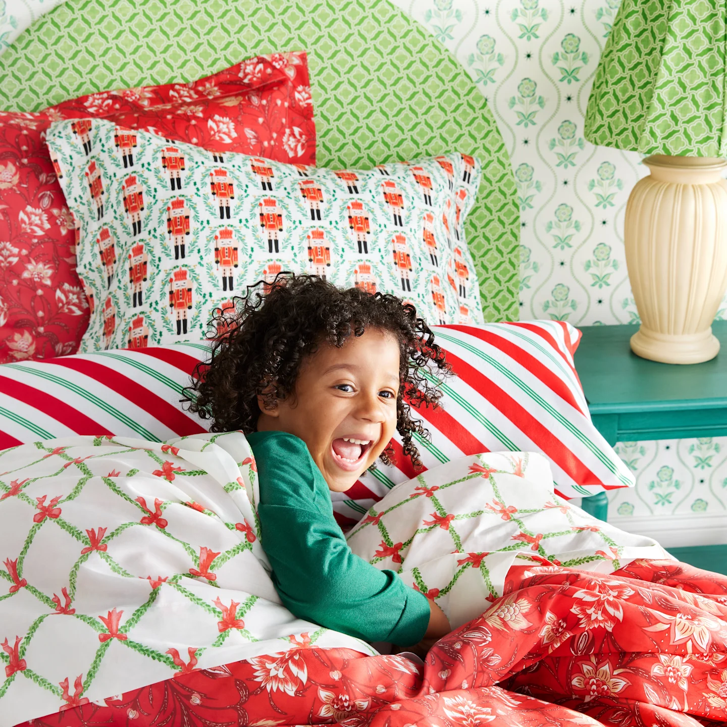 A kids' bed with pillows in Spoonflower pillow shams, accented by a geometric throw pillow.