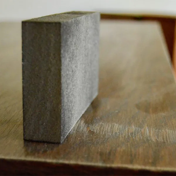 A close up of a sandpaper block sits on the top of the dresser .