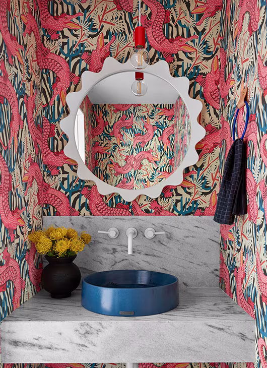 Whimsical alligator wallpaper in a bathroom with a blue sink