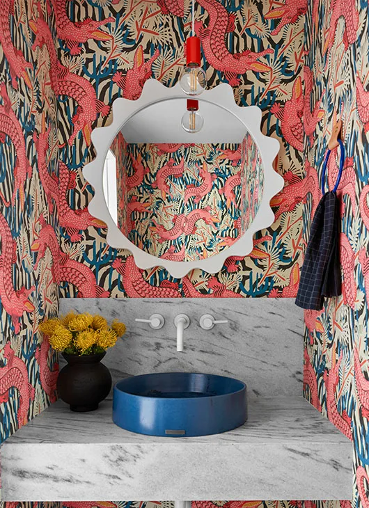 Whimsical alligator wallpaper in a bathroom with a blue sink