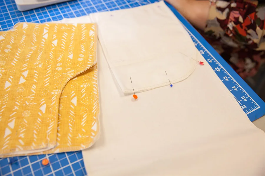 A close up of the front pocket and front pocket lining individually pinned for sewing.