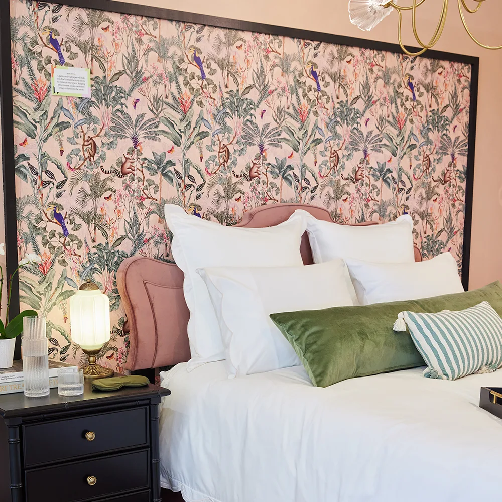 Bedroom with a backdrop behind the bed wallpapered in a Tropical Paradise design by smokeinthewoods.