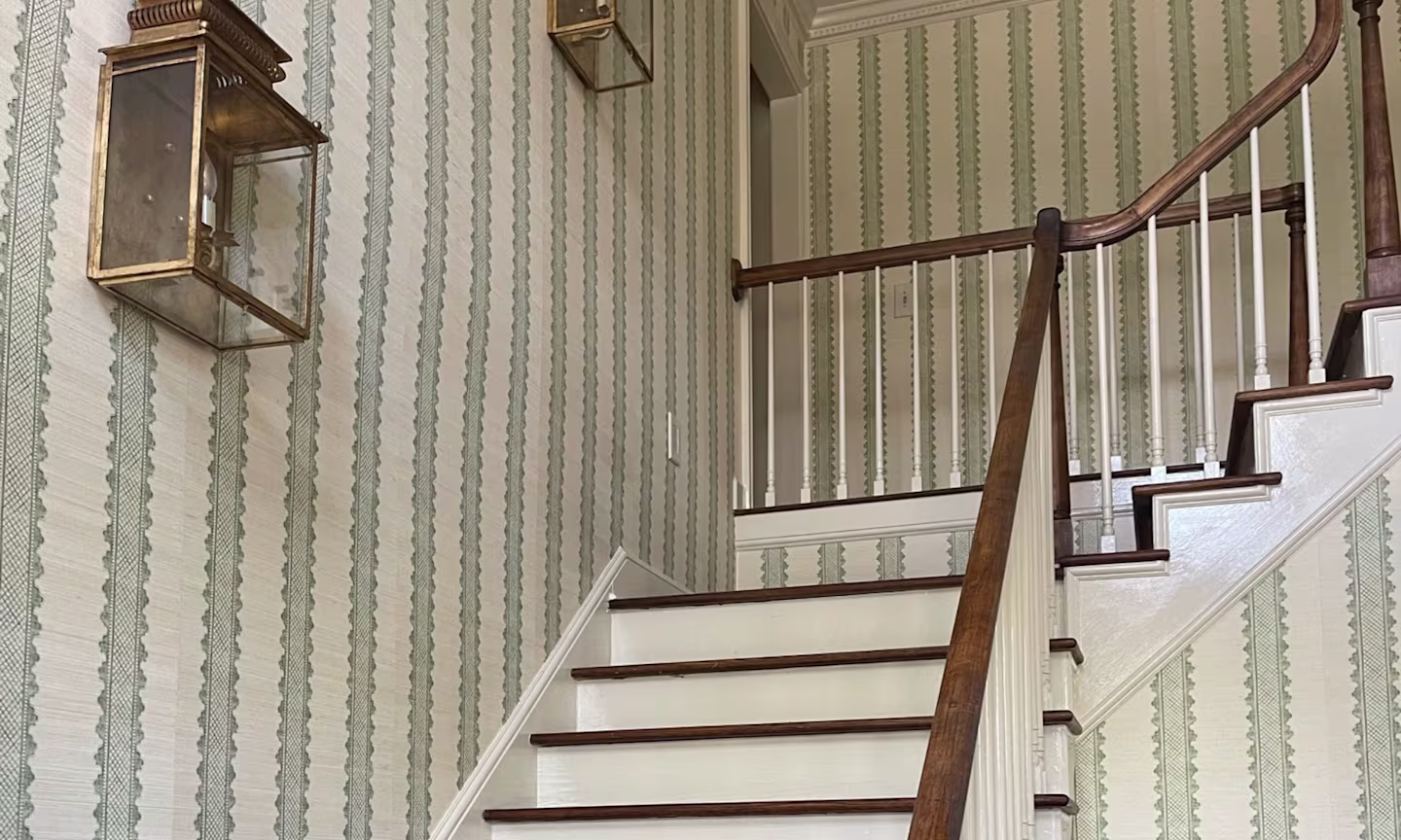 Staircase with green stripe grasscloth wallpaper