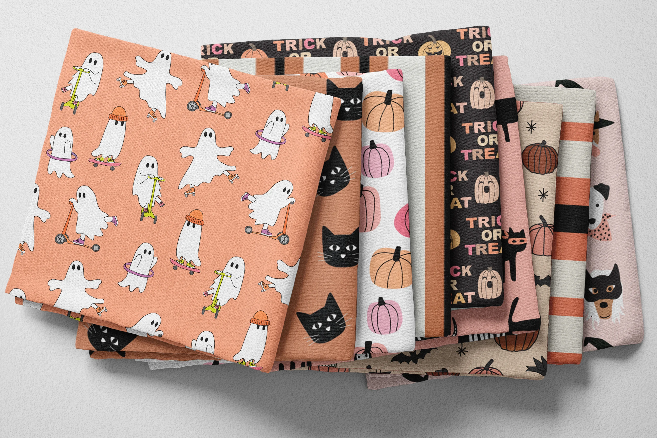 Colorful folded kids' halloween fabric in pumpkin orange, pink, beige, and black
