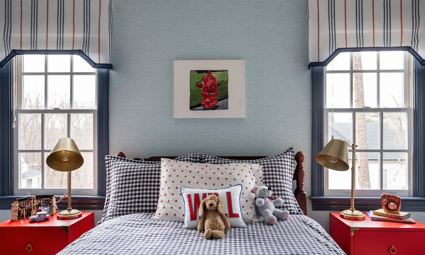 Boys bedroom with textured blue wallpaper, striped curtains and coordinating bedding.