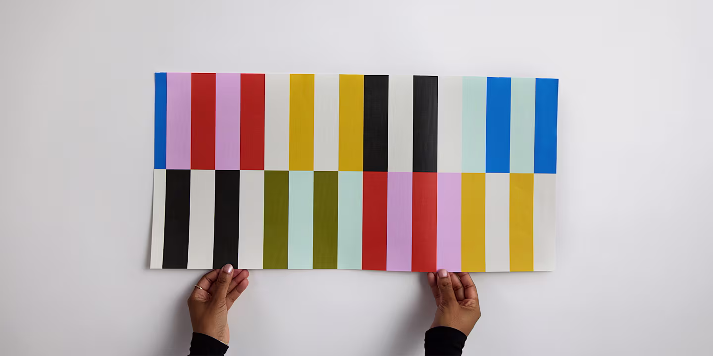 Hands holding a wallpaper sample.