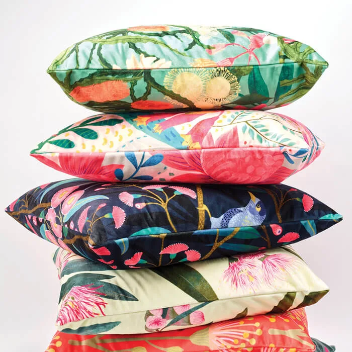 A tall stack of colorful throw pillows with bold floral and botanical prints