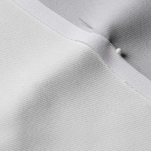 A close-up photo of white fabric with a pin running through it