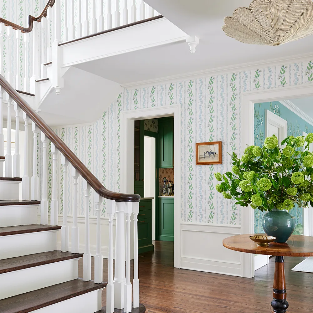 Neutral leaf wallpaper in an entryway.