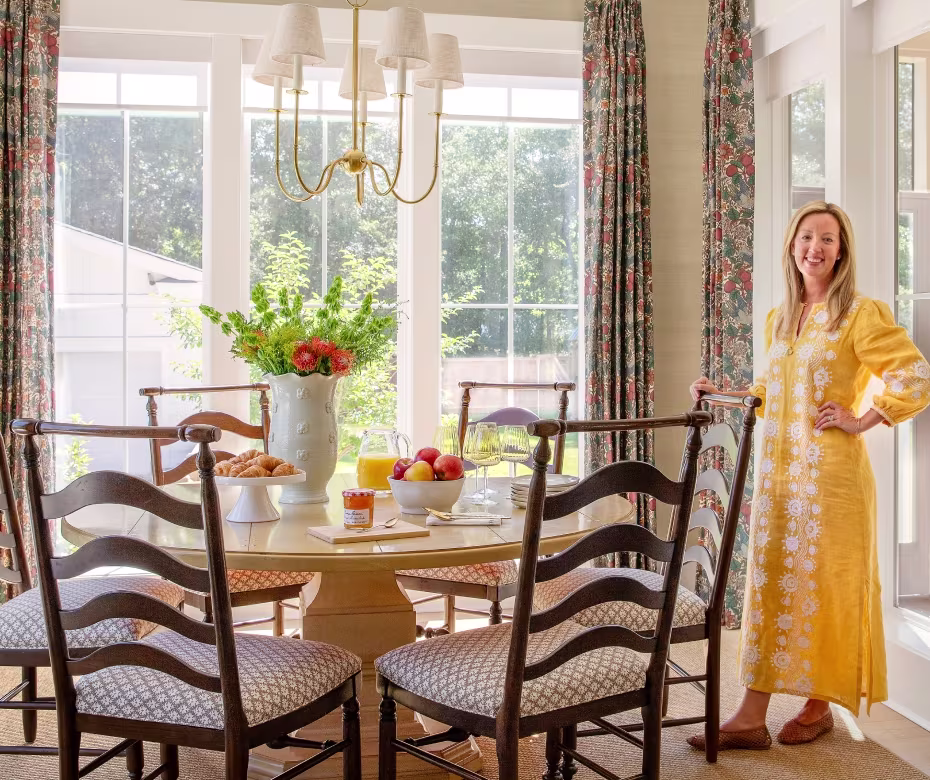 Molly Basile sitting in her dining room with croissants and fruit.