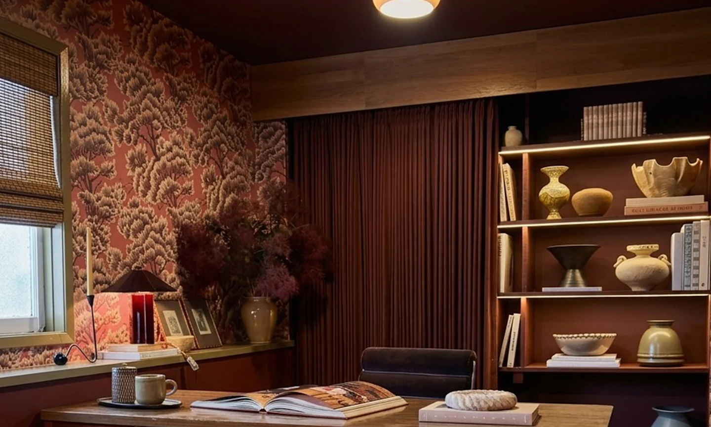 Office space with mauve tree wallpaper and moordy organic style.