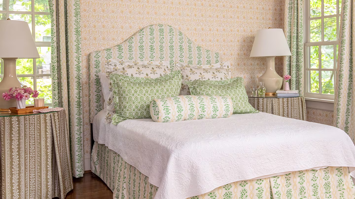 Green and pink bedroom with white bedding and green pillows.