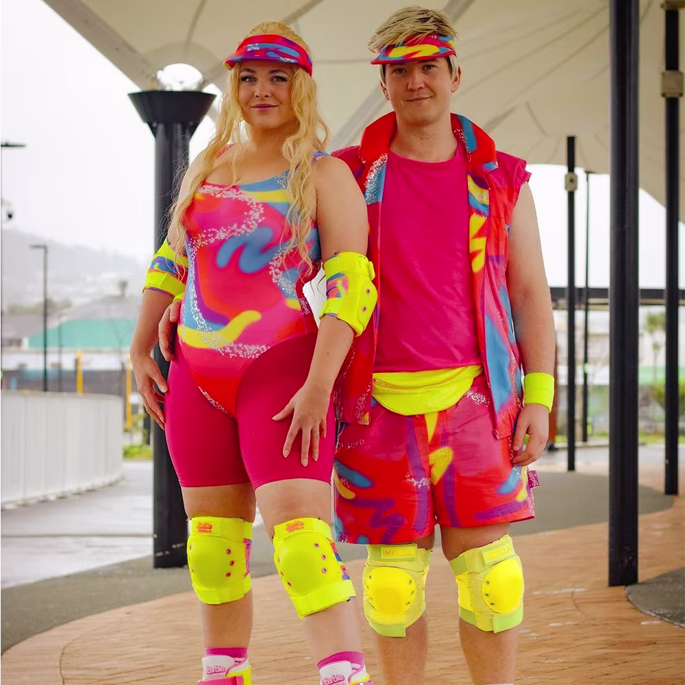 People dressed up as roller skating Barbie and Ken.
