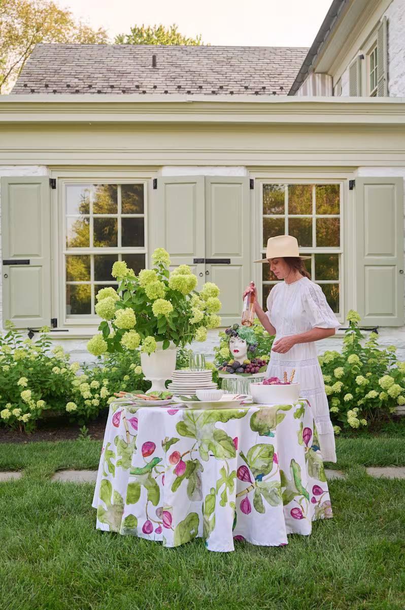 Outdoor tablescape with floral arrangements and fig print tablecloth