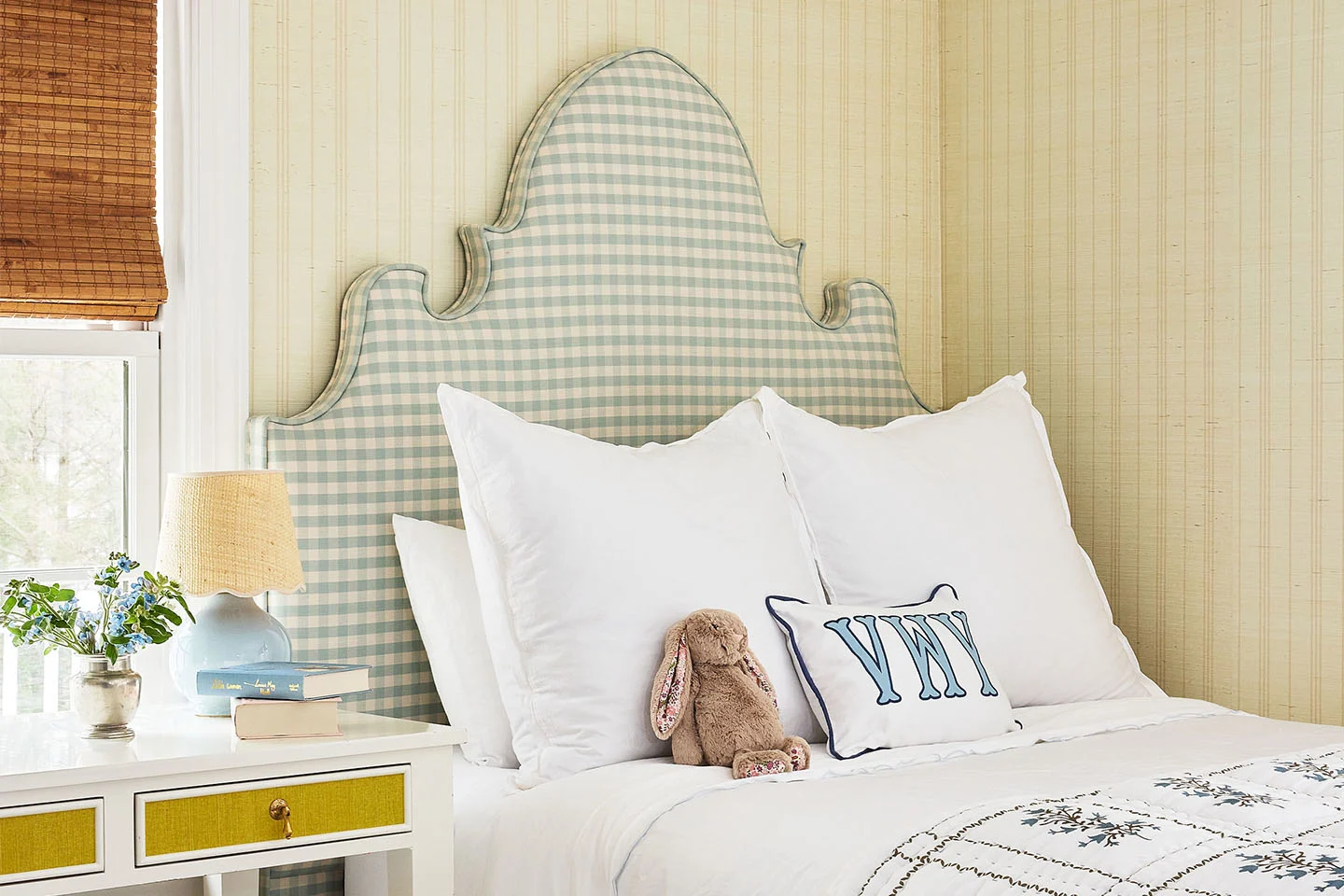 A traditional, classic yellow wallpaper and sage and cream checkered headboard in bedroom.