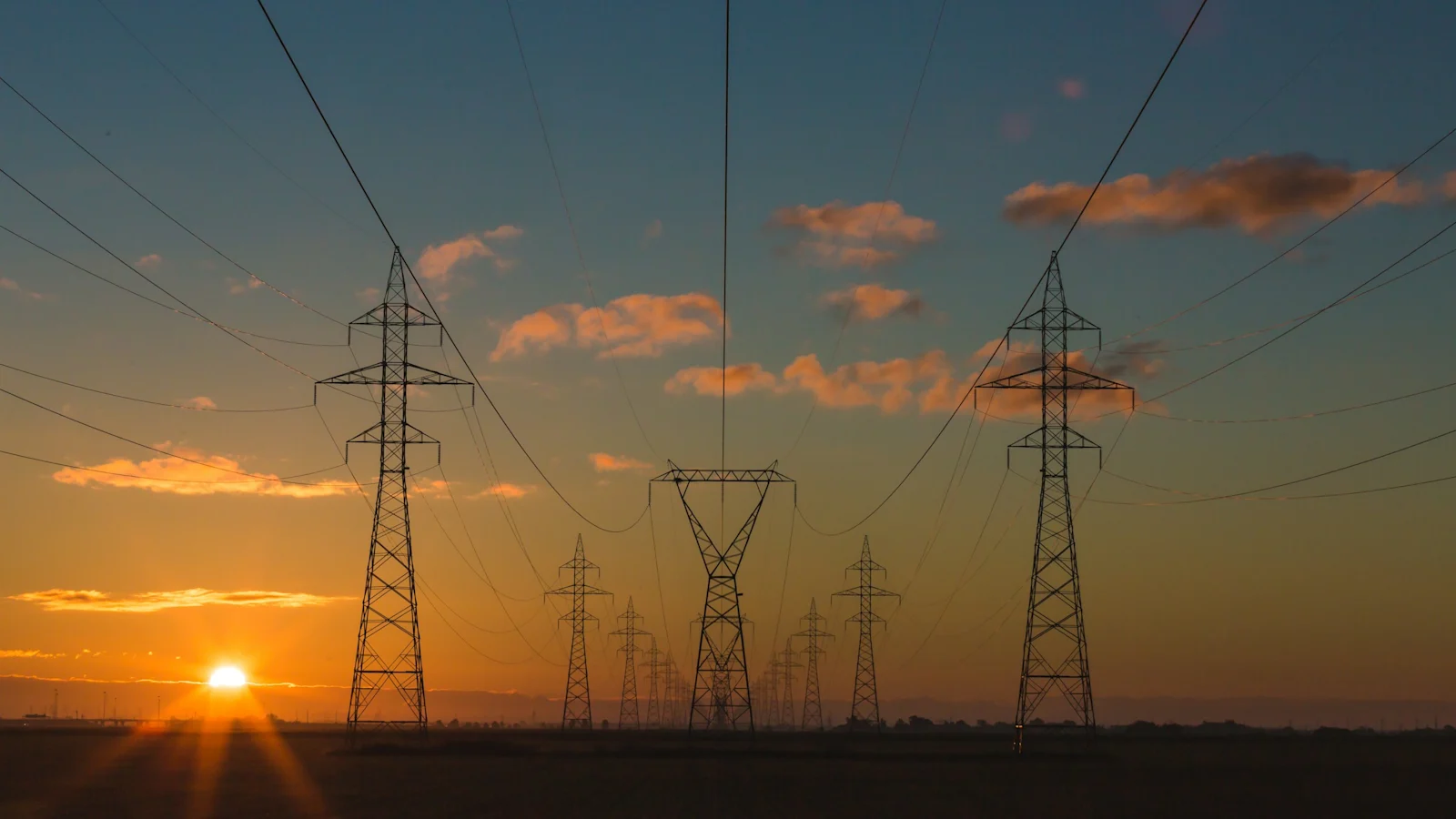 India now has two power prices, and only one of them is falling. Power pylons at sunset