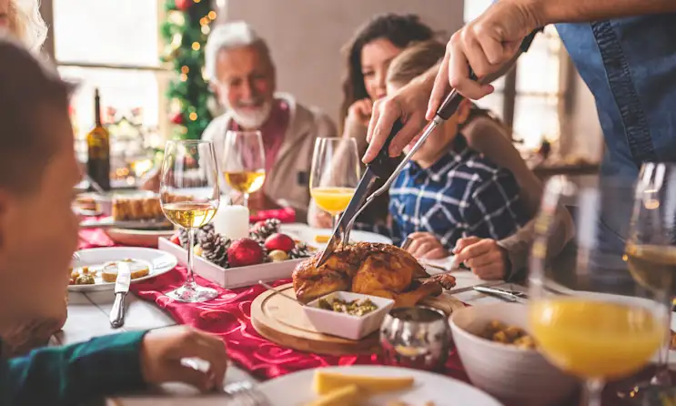 a group of people sitting at a table with a cake