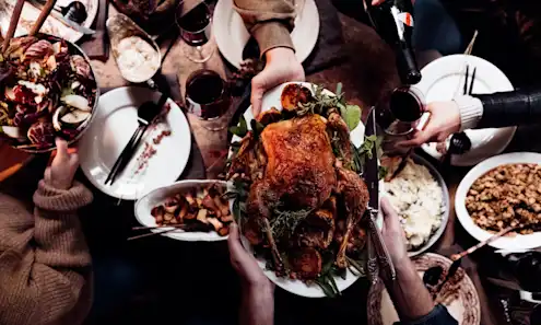 a group of people sitting at a table with plates of food