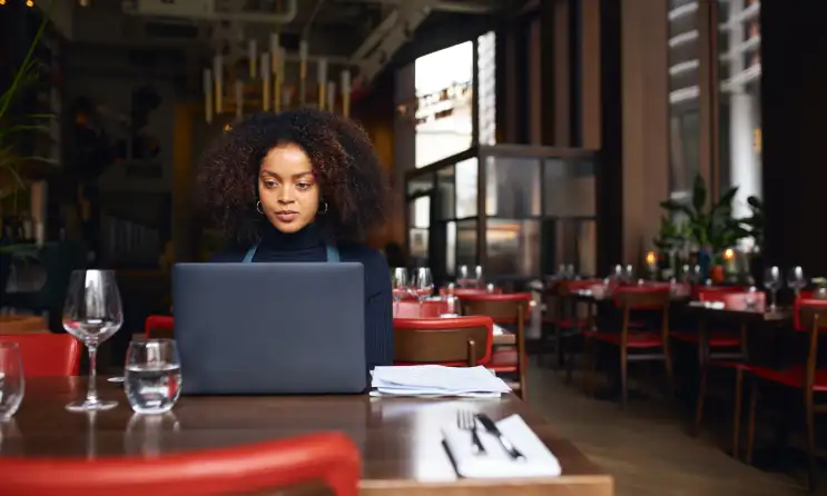 Woman working on her computer at a restaurant