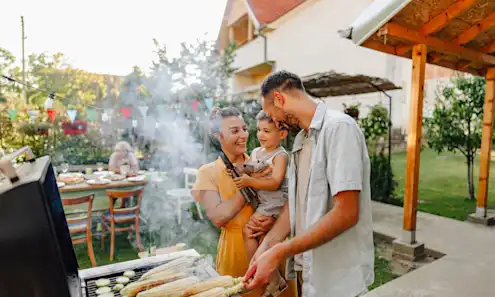 A family of three grilling in the backyard