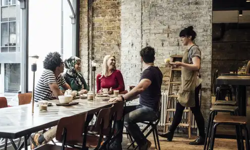 a group of people sitting at a table in a restaurant